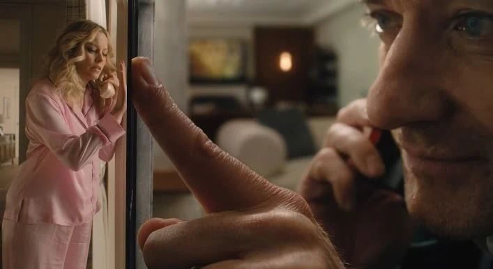 Still from The Miniature Wife: a man peers at his tiny wife in pink pyjamas